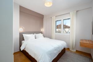 a bedroom with a white bed and a window at The 764 Residence - Kalavryta Town center in Kalavrita