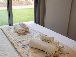 ein Bett mit Handtüchern und einem Fenster in der Unterkunft Villa Giuseppe Seaside in Lido Di Fondi
