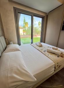 zwei Betten in einem Zimmer mit großem Fenster in der Unterkunft Villa Giuseppe Seaside in Lido Di Fondi