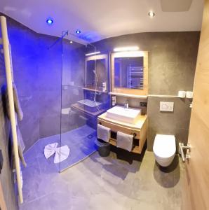 een badkamer met een wastafel, een toilet en een douche bij B&B Gästehaus Alpenblick in Lermoos +36 foto's