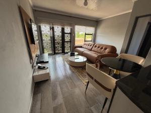 ein Wohnzimmer mit Sofa und Tisch in der Unterkunft The Residence Apartments in Maseru