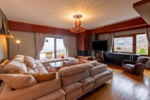 a living room with a large couch and a television at K Ardamis Estate in Kastoria