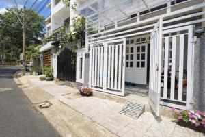 een witte poort aan de zijkant van een gebouw bij Ichigo Home Đà Lạt in Da Lat