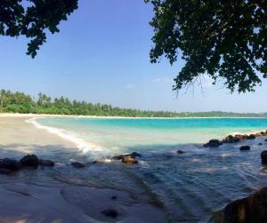 a view of a beach with rocks and water at Jungle Room in Talalla South +6 photos