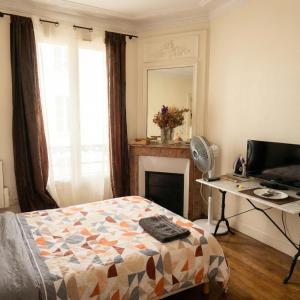 een slaapkamer met een bed, een bureau en een spiegel bij A spacious room in a strategic area in Montrouge