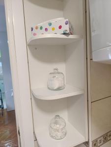 een witte kast met twee glazen schalen en een doos bij Apartman 32 in Inđija