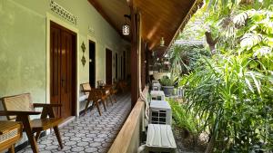 an outdoor patio with tables and benches and plants at The Heritage Kraton Guest House in Timuran
