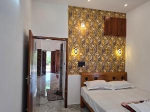 une chambre avec un lit et un mur carrelé dans l'établissement Riverbank Gardens, à Mananthavady