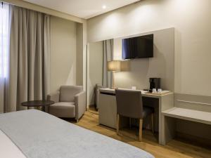 una camera d'albergo con scrivania e sedia di Mercure Carlton Rioja a Logroño