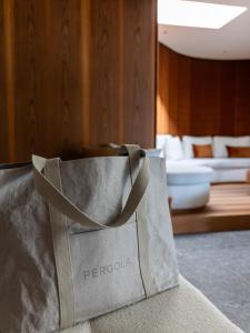 un sac gris posé sur un canapé dans l'établissement Pergola Residence, à Lagundo