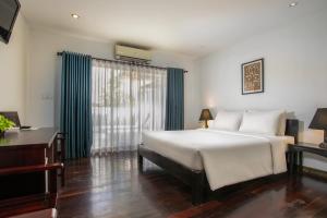 een slaapkamer met een groot wit bed en een bureau bij Apsara Centrepole Hotel in Siem Reap +117 foto's