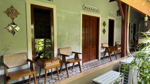 a porch of a house with chairs and a door at The Heritage Kraton Guest House in Timuran