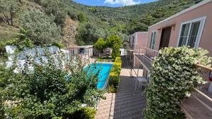 a house with a swimming pool and mountains in the background at Ali Baba Butik Otel in Gündoğdu