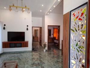 un salon avec une télévision sur un mur dans l'établissement Riverbank Gardens, à Mananthavady 75 autres photos