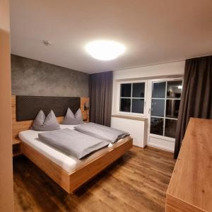 een slaapkamer met een groot bed en twee ramen bij B&B Gästehaus Alpenblick in Lermoos