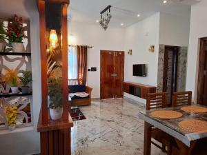 un salon avec une table et une télévision dans l'établissement Riverbank Gardens, à Mananthavady