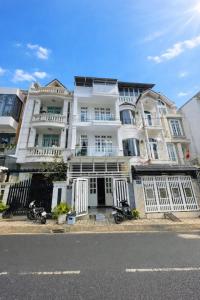 een groot wit gebouw met motoren voor het gebouw bij Ichigo Home Đà Lạt in Da Lat