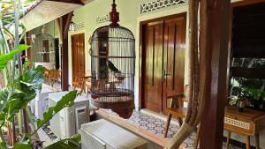 a bird in a bird cage on a porch at The Heritage Kraton Guest House in Timuran +32 photos