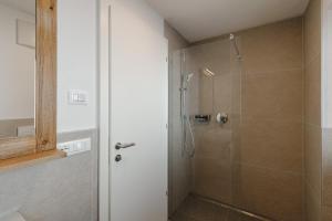een douche met een glazen deur in een badkamer bij Appartamento Piz Boe' in Arabba