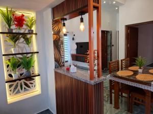 une cuisine et une salle à manger avec une table et une télévision dans l'établissement Riverbank Gardens, à Mananthavady
