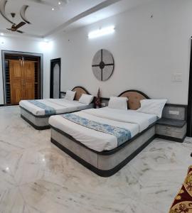 two beds in a large room with a clock on the wall at Nature Escape Villa in Jodhpur