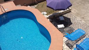an overhead view of a swimming pool with an umbrella and chairs at Casa Fuile Cala Liberotto Orosei in Cala Liberotto