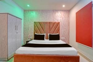 una camera da letto con un letto grande e una parete rossa di Hotel O Ace a Rohtak