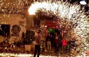 Ein Mann steht mit Wunderkerzen vor einem Brunnen. in der Unterkunft Dali Lily Guest House, close to the Honglongjing Gate of the ancient city,only 200 meters ,near the Cangshan and Erhai Lake,English-speaking service, convenient payment in Dali Ancient Town