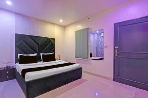 una camera da letto con un letto grande con una grande testiera di Hotel O Ace a Rohtak