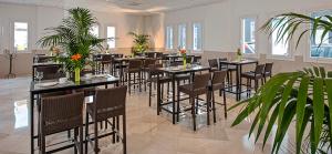 uma sala de jantar com mesas, cadeiras e plantas em Hostal Tarifa em Tarifa