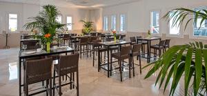 a dining room with tables and chairs and plants at Hostal Tarifa in Tarifa