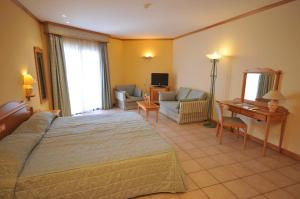a bedroom with a bed and a living room at Grand Hotel Gozo in Għajnsielem