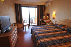 a hotel room with a bed and a television at Grand Hotel Gozo in Għajnsielem