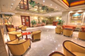 a lobby with a waiting room with chairs and tables at Grand Hotel Gozo in Għajnsielem