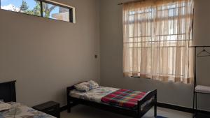 een slaapkamer met een bed en een raam bij Dans place in Moshi