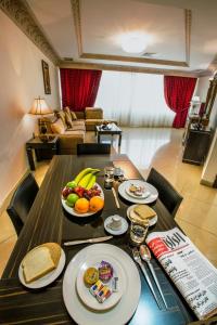 a table with plates of food and fruit on it at Sara Palace Apartments- family only in Kuwait