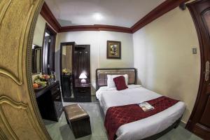 um quarto de hotel com uma cama e um espelho em Sara Palace Apartments- family only em Kuwait