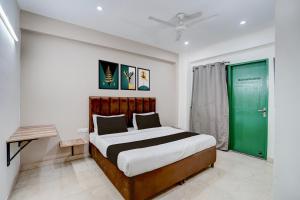een slaapkamer met een groot bed en een groene deur bij Collection O by OYO HOTEL DLF PHASE-4 MG ROAD in Gurgaon