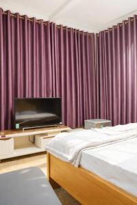 a bedroom with a bed and a flat screen tv at Du Thuyền Hotel Hồ Chí Minh in Ho Chi Minh City