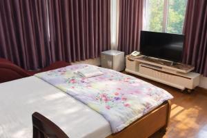 a bedroom with a bed and a flat screen tv at Du Thuyền Hotel Hồ Chí Minh in Ho Chi Minh City