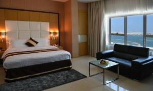 a hotel room with a bed and a couch at Al Olaya Suites Hotel in Manama