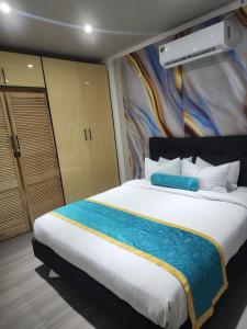 - une chambre avec un grand lit blanc et une couverture bleue dans l'établissement MakutuBnB, Nadi, à Nadi