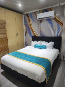 een slaapkamer met een groot bed met een blauw item erop bij MakutuBnB, Nadi in Nadi