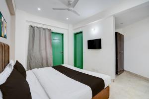 een slaapkamer met een bed en een groene deur bij Collection O by OYO HOTEL DLF PHASE-4 MG ROAD in Gurgaon +49 foto's