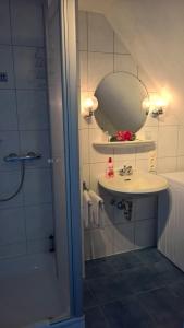 ein Bad mit einem Waschbecken und einer Dusche mit einem Spiegel in der Unterkunft Ostsee in Papenburg