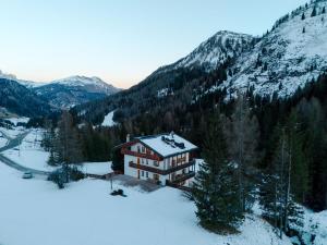 een huis midden in een met sneeuw bedekte berg bij Appartamento Borésc in Arabba