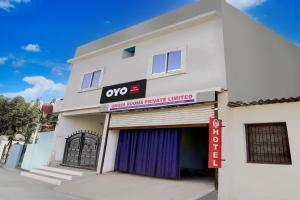 un edificio bianco con un cartello Qop sopra di SPOT ON Hotel Omava Inn a Garhā Altre 21 foto