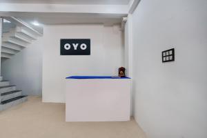 un muro bianco con una porta con un cartello sopra di SPOT ON Hotel Omava Inn a Garhā