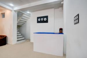 un muro bianco con un cartello accanto a una scala di SPOT ON Hotel Omava Inn a Garhā