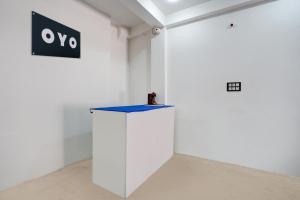 una stanza con una parete bianca e un tavolo blu di SPOT ON Hotel Omava Inn a Garhā